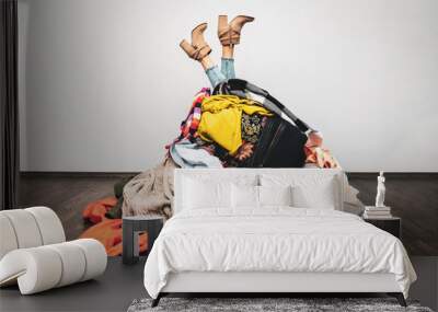 woman legs out of a pile of clothes on the floor. shopping addiction concept Wall mural