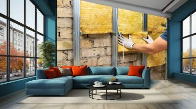 worker insulating old brick wall with glass wool sheets Wall mural