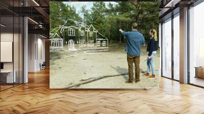 young couple looking at their family dream house in forest Wall mural