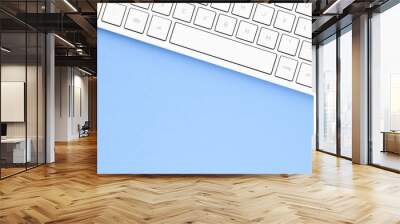 Close up white computer keyboard on blue background. View from above. Wall mural