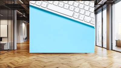 Close up white computer keyboard on blue background. View from above. Wall mural