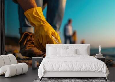 A community of volunteers cleaning a beach, with the focus on one person picking up trash, wide-angle shot with a clean, expansive shoreline offering room for copy Wall mural