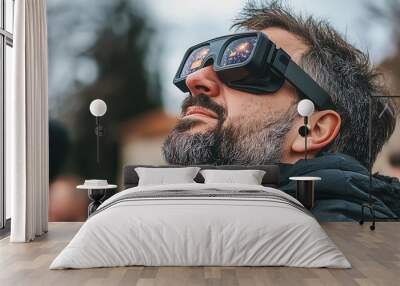 A man wearing modern VR goggles gazes upward, captivated by an immersive experience in a technology-driven environment Wall mural