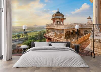 Agra Fort - Medieval Indian fort made of red sandstone and marble with view of dome at sunrise. View of Taj Mahal at a distance as seen from Agra Fort. Wall mural