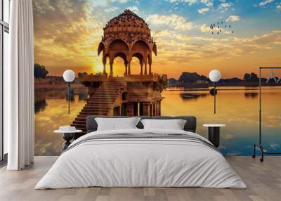 ancient architecture ruins at gadi sagar (gadisar) lake jaipur rajasthan at sunrise with vibrant moo Wall mural