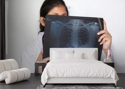 India doctor in face mask examines a chest x-ray plate at a healthcare center Wall mural