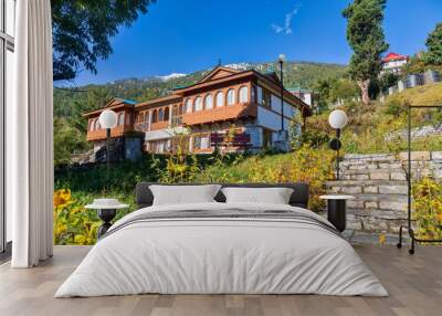 wooden tourist lodge with flower garden built on the mountain slopes with himalayan landscape at kal Wall mural