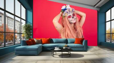 young beautiful woman wearing halloween make up over red background stretching arms, relaxed position. Wall mural