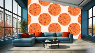 Repetitive pattern made of small orange pumpkin on a beige background. Wall mural