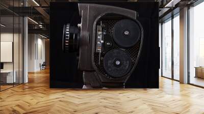 Photograph of an old 8mm movie camera under artificial lighting on a black background. Retro camera from a personal collection in a beautiful perspective, covered with dust and scratches during storag Wall mural