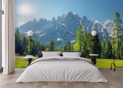 Breathtaking alpine landscape with majestic snow-capped mountains, lush green forest, and a bright blue sky under the radiant sun Wall mural