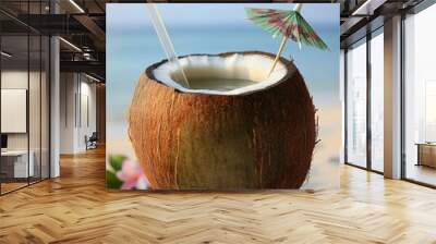 Refreshing coconut drink with an umbrella on a tropical beach, perfect for a summer vacation, capturing the essence of island relaxation Wall mural