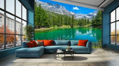 Small alpine lake and mountain ridge under blue sky in Italy. Wall mural