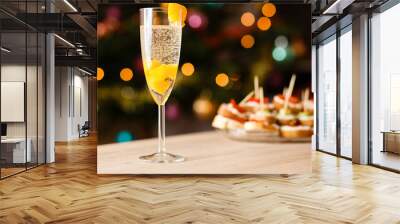 A glass of sparkling wine with apricot on the table Wall mural