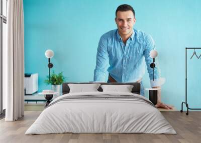 Happy man leaning on a table Wall mural