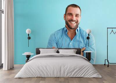 Happy man standing in front of turquoise wall Wall mural