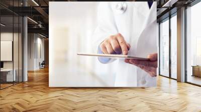 Male doctor using his digital tablet in the hospital Wall mural