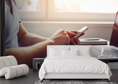 Man using smartphone in the office at sunset Wall mural