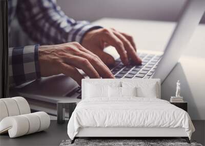 Man working on a laptop in office Wall mural