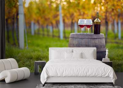 Two glasses of red wine on a wooden barrel in an autumn vineyard Wall mural