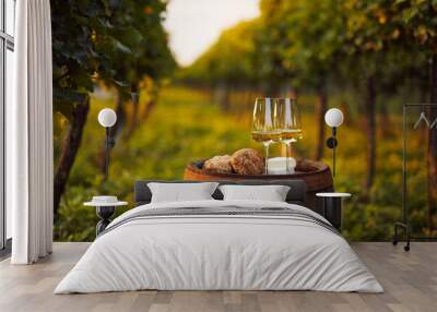 Two glasses of white wine on an old barrel in the vineyard Wall mural