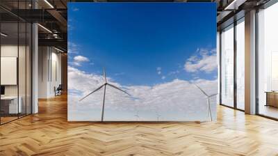 Massive windmills in the field on the background of the blue sky Wall mural