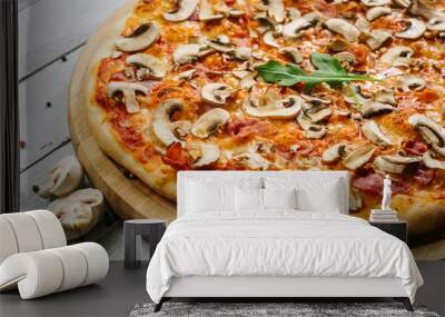 Tasty pizza Caprizzioza with tomato sauce, ham and champignons on the white wooden background Wall mural