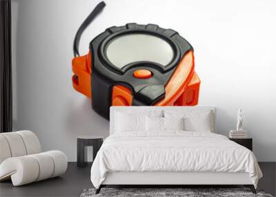 Measuring tape in an orange and black plastic case, with a metal ruler, on a white background Wall mural