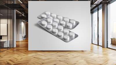 Two blister packs with white tablets on a white background Wall mural