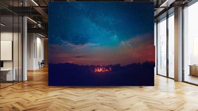 Camping fire under the amazing blue starry sky with a lot of shining stars and clouds. Travel recreational outdoor activity concept. Wall mural