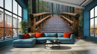 A wooden bridge in a misty forest with fallen leaves on the ground. Wall mural