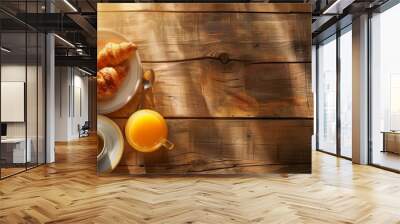 Rustic breakfast with croissants, coffee, and orange juice on a wooden table in sunlight Wall mural