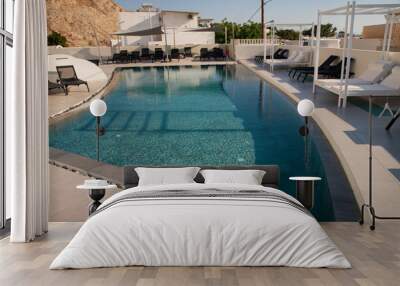 Small pool on the island of Santorini in Greece in Kamari. Clear water and sun beds and a gazebo for sunbathing. Wall mural