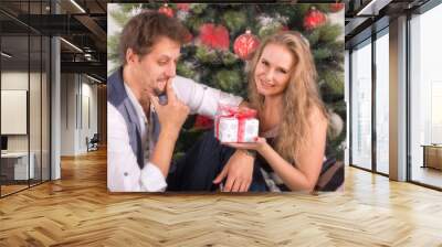 loving couple of young people give each other Christmas gifts Wall mural