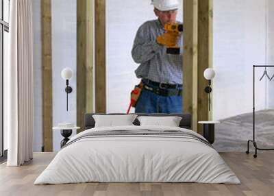 carpenter drilling into some timber framework in a new home. Wall mural