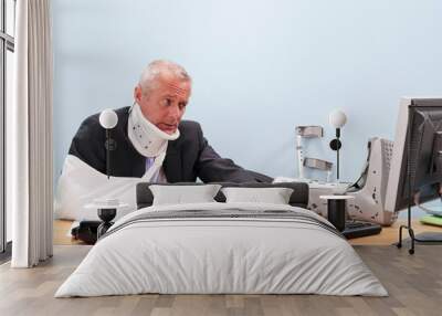 injured businessman working at his desk Wall mural