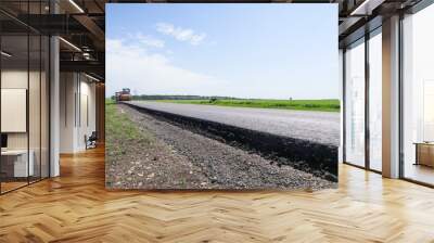 New asphalt road surface on the background of green and yellow fields to the horizon. The level of old and new asphalt. Highway on the background of a rural landscape. Horizontal line the roadside     Wall mural