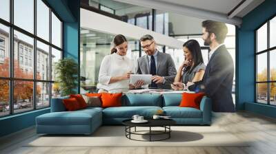 Achieving success together. Shot of a group of colleagues discussing business in the office. Wall mural