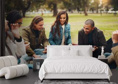 I dont know where to start. Shot of a group of cheerful young friends having a picnic together outside in a park during the day. Wall mural