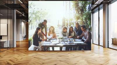 Improving productivity with a change of scenery. Shot of a group of colleagues having a meeting at a cafe. Wall mural