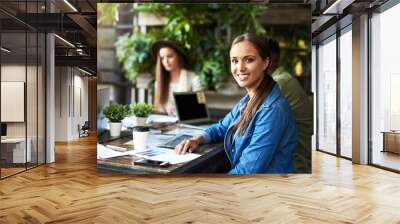 Success comes when you think outside the box. Portrait of a young designer having a meeting with her colleagues at a coffee shop. Wall mural