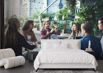 Work outside the box. Shot of a group of designers having a meeting at a coffee shop. Wall mural