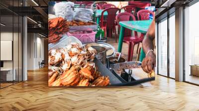 Male hand of a cook cooking seafood outdoors in a street market in Colombo, Sri Lanka Wall mural