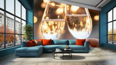 Two sparkling glasses toast against a backdrop of festive lights, symbolizing celebration and joy in a romantic atmosphere. Wall mural