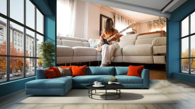 asian girl playing the bass in her living room.  Wall mural