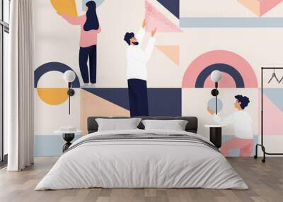 Team of three people arranging geometric shapes into an abstract design Wall mural