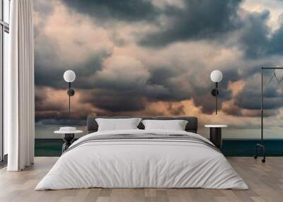 Rain clouds tightened the whole sky above the sea at sunset Wall mural