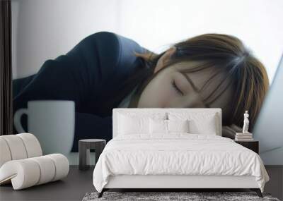 A woman is sleeping on a laptop with a cup of coffee next to her Wall mural