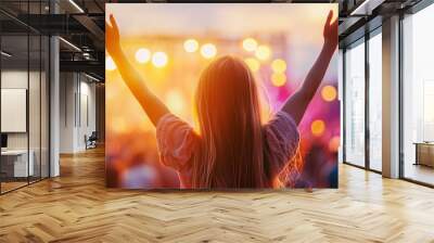 A woman is standing in a crowd of people, with her arms raised in the air Wall mural