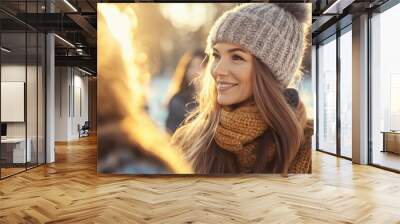 A woman wearing a hat and scarf is smiling at the camera Wall mural